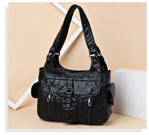 Detailed view of black PU leather shoulder bag with pleated texture and metal zippers