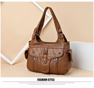 Detail of caramel faux leather bag featuring dual front pockets and polished hardware