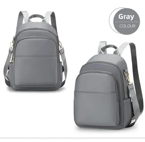 Vue détaillée d'un sac à dos gris en nylon imperméable avec fermetures éclair dorées