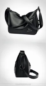 Detail view of black lychee grain leather crossbody bag with adjustable wide strap