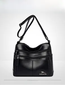 Detailed view of black litchi textured leather handbag with metallic logo and zippers