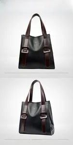 Detail view of black lychee grain leather tote bag with brown straps and kangaroo logo