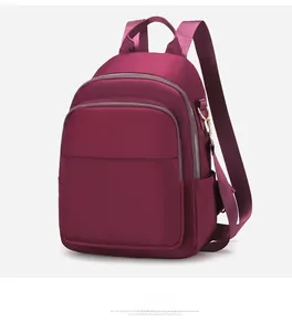 Vue latérale du sac à dos élégant en tissu oxford bordeaux avec fermetures éclair dorées