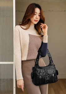 Detail of vintage black soft leather shoulder bag featuring washed texture and multi-pockets