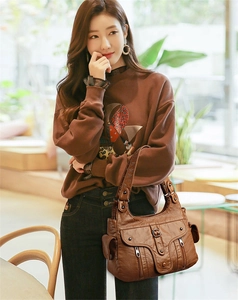 Detailed view of dark brown faux leather shoulder bag with multiple functional zip pockets