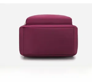 Détails du fond plat du sac à dos bordeaux en nylon avec des coutures soignées et résistantes