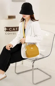 Borsa a conchiglia in nylon giallo senape indossata da una modella in un contesto lifestyle