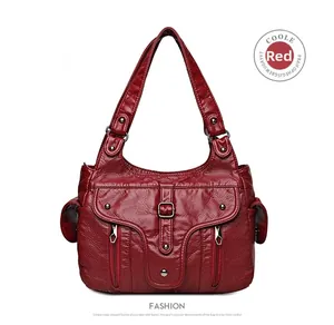 Detail of red faux leather shoulder bag with multiple pockets and silver hardware