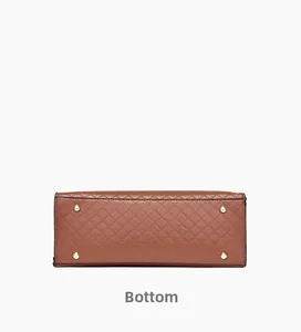 Detail view of the caramel quilted leather bag bottom with golden metal feet