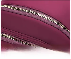 Vue macro de doubles fermetures éclair dorées sur un tissu en nylon violet texturé