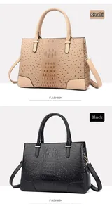 Detail der Handtasche mit Krokodil- und Straußenprägung in den Farben Khaki und Schwarz