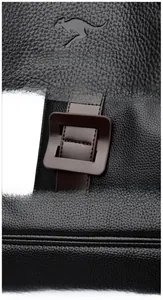 Detail of black lychee grain leather handbag featuring embossed logo and fine stitching