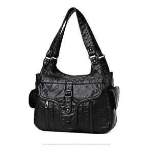 Detail of black washed PU leather shoulder bag featuring multiple functional pockets and textures