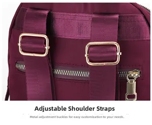 Détail d'un sac à dos en nylon bordeaux avec bretelles réglables et boucles dorées chic