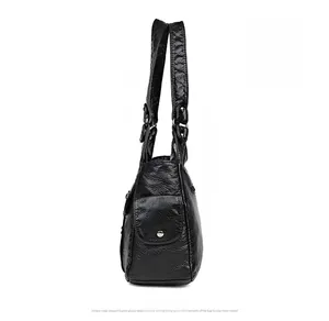 Detail view of black washed leather tote bag with side button pocket and metal rivets