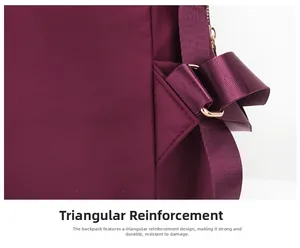 Gros plan du renfort triangulaire et de la boucle dorée sur le sac à dos en nylon bordeaux