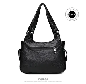 Detail view of the black washed leather tote bag showing back zipper pocket and side pockets