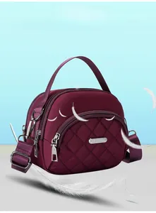 Dettaglio borsa a tracolla in nylon trapuntato viola con finiture argento e manico