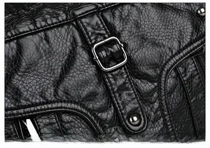 Close-up of vintage black washed leather tote bag with silver square buckle and rivets