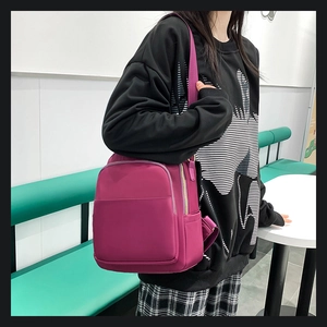 Détail du sac à dos en nylon magenta avec fermetures éclair et poche frontale large