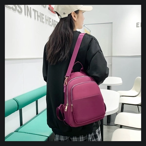 Vue latérale du sac à dos en nylon violet avec fermetures éclair dorées porté par mannequin