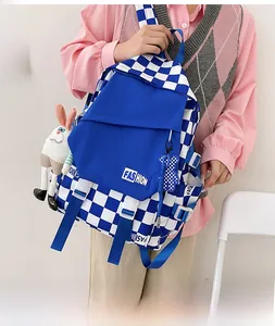 Detail of blue checkerboard backpack with fashion label and cute plush pendant charms