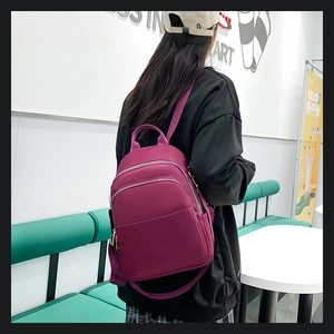 Sac à dos mode en tissu Oxford violet avec plusieurs poches zippées sur un mannequin