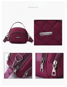Dettaglio borsa in nylon trapuntato bordeaux con fibbie argentate e tracolla