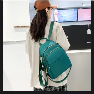 Détail du sac à dos en nylon vert foncé étanche avec compartiments et fermetures dorées