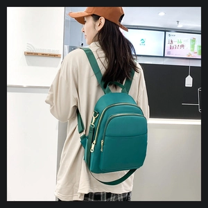 Vue détaillée du sac à dos en nylon vert foncé avec double fermeture et bretelles