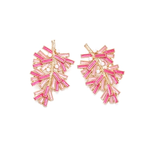 Detail of gold-tone branch earrings with pink enamel leaves and white pearl accents