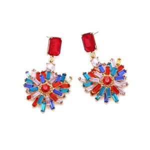 Close-up of heart-shaped drop earrings featuring multi-color crystals in gold setting