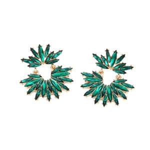 Close-up of golden floral fan earrings with green marquise crystals on white background