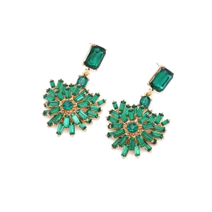 Detailed close-up of heart earrings with emerald green crystals and gold setting