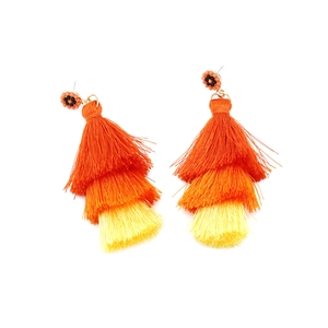 Detail of bohemian long tassel earrings with warm orange gradient fringe and beadwork