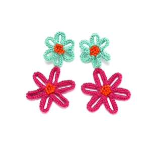 Detailed close-up of handmade crochet flower earrings featuring mint green and magenta petals