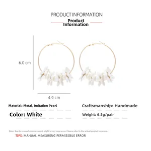 Detail view of floral pearl hoop earrings with measurements 6.0cm by 4.9cm and metal finish