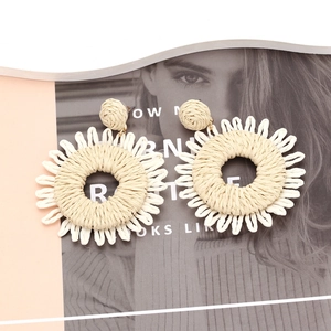 Handmade raffia sunflower earrings in bohemian style with woven cream floral texture