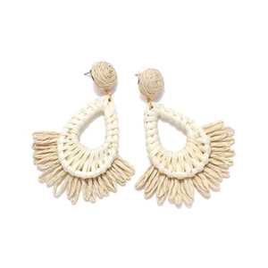 Close-up of bohemian hand-woven raffia earrings with natural texture and fringe