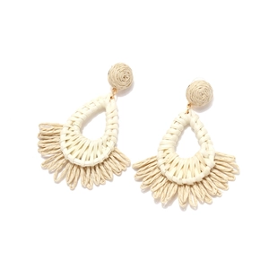 Detailed view of handmade raffia tassel drop earrings in bohemian beige woven style