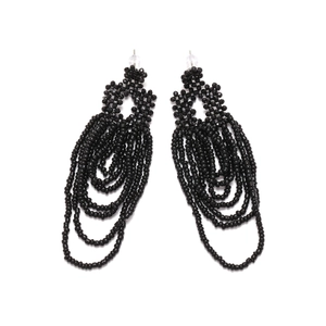 Macro detail of black handmade beaded tassel earrings with bohemian geometric fringe layers