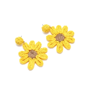 Detailed view of handmade raffia sunflower earrings with yellow petals and brown center