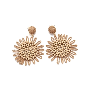 Close-up of handmade raffia sunflower earrings with delicate cream bead centers