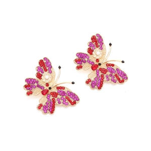 Detailed macro view of butterfly earrings featuring colorful rhinestones and imitation pearls