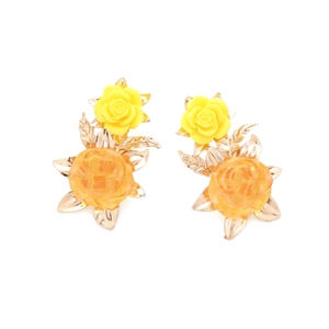 Detailed macro view of retro resin flower earrings with orange petals and golden leaves