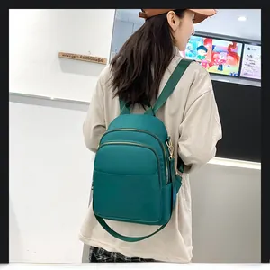 Vue latérale d'un sac à dos en nylon vert foncé pour femme avec plusieurs poches