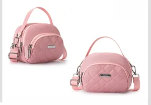 Dettaglio della borsa rosa in nylon impermeabile con cuciture a rombi e logo in metallo