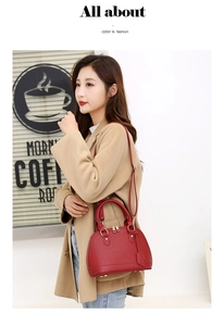 Detailed view of red crocodile texture shell handbag with gold hardware and strap