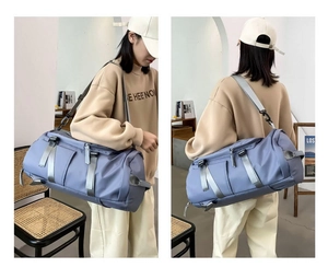Detail showing the adjustable shoulder strap and reinforced handles on the blue travel bag