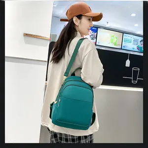 Vue latérale du sac à dos en nylon vert foncé avec bretelles réglables et fermetures